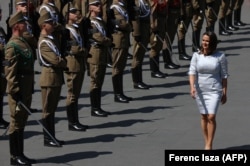 Hungarian President Katalin President inspects a military honor guard during her inauguration in Budapest on May 14, 2022.