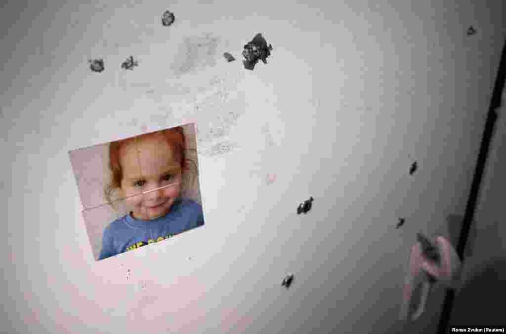 A picture of an abducted girl is stuck to the door of a safety room with bullet impacts following the deadly October 7 attack on the Kibbutz Nir Oz in southern Israel, on November 21, 2023.