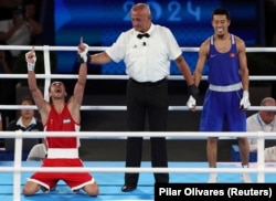 Abdumalik Khalokov (left) of Uzbekistan celebrates after getting the decision against Munarbek Seiitbek-uulu of Kyrgyzstan on August 10 in Paris.