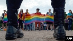 Police officers watch as people wave rainbow flags during a gay pride rally in St. Petersburg in 2017.