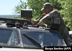 A Ukrainian soldier fits a drone jamming device onto an armored vehicle in the Donetsk region in April.