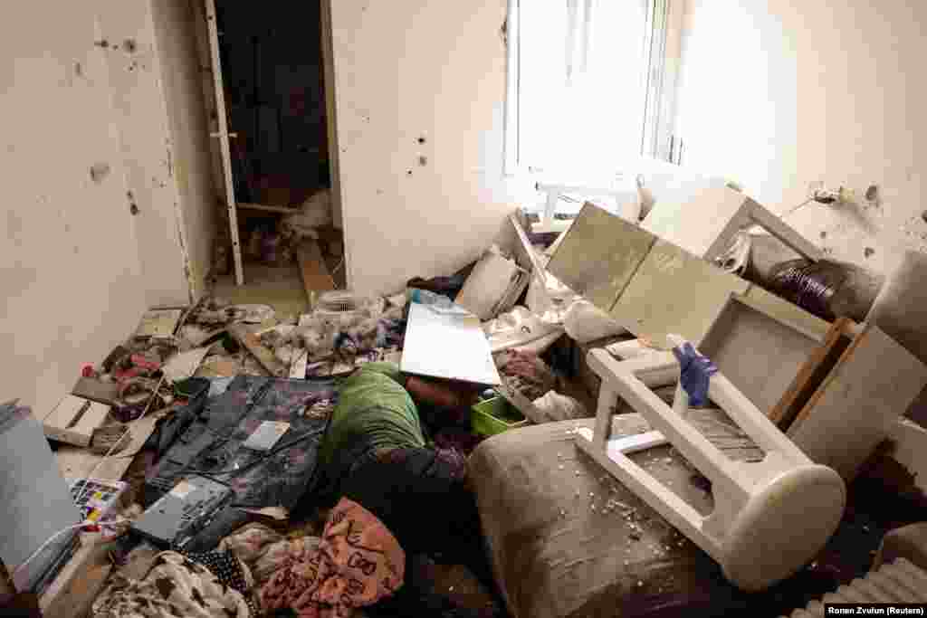 The body of a man lies among rubble following an attack by Hamas gunmen on the Kibbutz Kfar Aza in southern Israel on October 10, 2023.