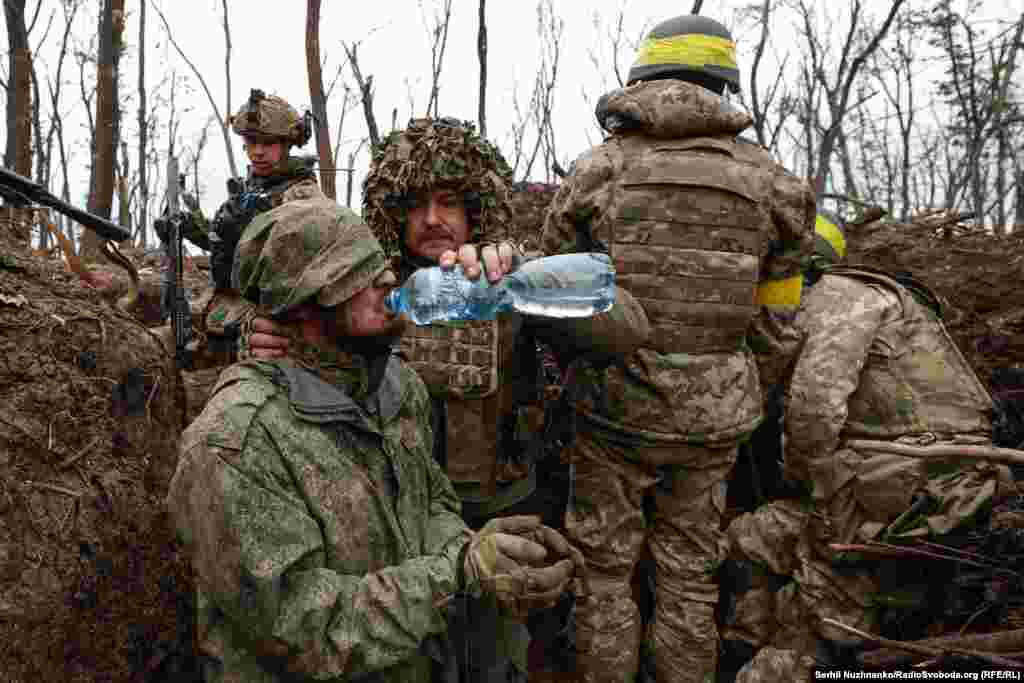 A Russian soldier is given water after his capture by Ukrainian forces near Bakhmut in May, 2023.&nbsp; 