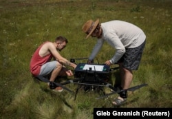 Employees of Ukraine's Swarmer drone company prepare an AI-enabled quadcopter for flight in the Kyiv region in June.