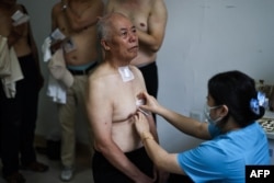 A man has medicinal patches applied at a traditional Chinese medicine hospital in Shenyang, China in July.