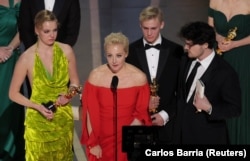 Yulia Navalny, the wife of jailed dissident Alexei Navalny, speaks next to her daughter Daria and director Roher at the Oscars ceremony on March 12.