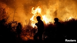 Firemen in southern Israel work to put out a blaze started after Hamas and other militants launched coordinated attacks across the border from Gaza on October 7, 2023.