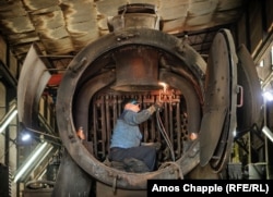 A worker inside the boiler of a Kriegslok at a maintenance station for the trains near Tuzla.