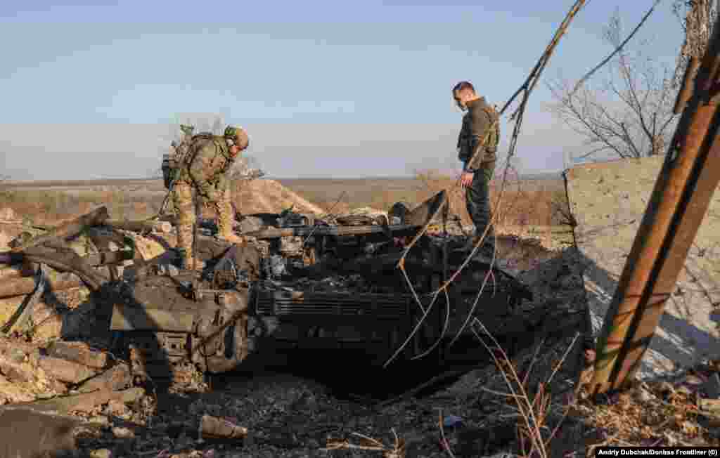 Ukrainian troops examine a destroyed tank. Dubchak says he asked locals whether possible war crimes took place in Snihurivka during its occupation by Russian forces but says, &quot;For now, there is no information.&quot;&nbsp; &nbsp;