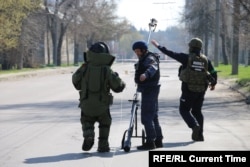 Sappers check for mines along a street in Kharkiv.