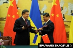 Ukrainian President Viktor Yanukovych (left) and Chinese President Xi Jinping sign agreements in Beijing during a December 2013 visit.