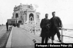 Two men pose for a picture on the seaside at Constanta in 1937 with the city’s famous coastal casino in the background.