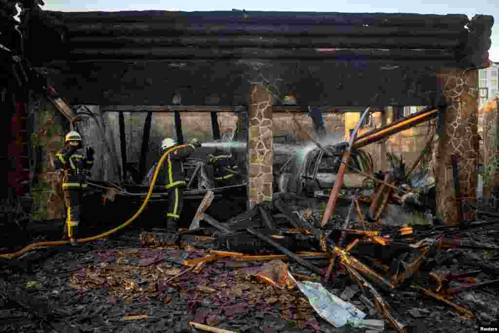 Ukrainian firefighters work at a site of a Russian drone strike in the Kyiv region.