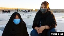 Maryam Behtarpour (left), the mother of Farzad Ansarifar, at the grave of her son, sits next to her daughter, Farzaneh. (file photo)