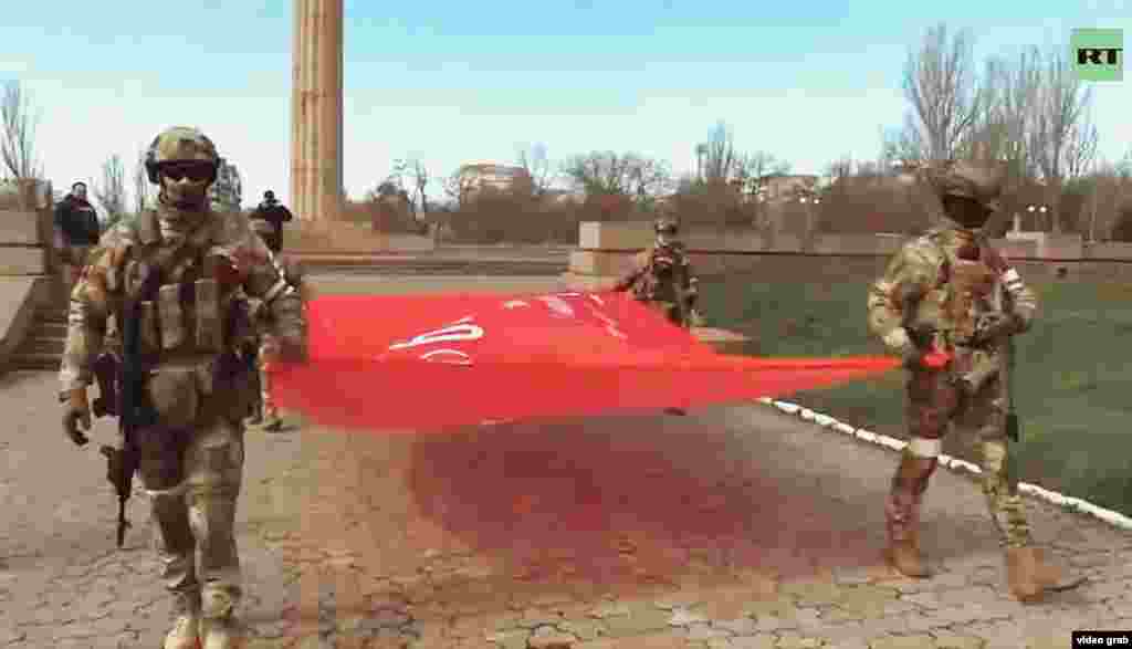 Occupying troops raise a Soviet victory banner, featuring the hammer and sickle, at Park Slavy (Park of Glory) in central Kherson. It&#39;s a copy of the flag raised over Berlin&#39;s Reichstag and is now an official symbol of the U.S.S.R.&#39;s victory over Nazi Germany.