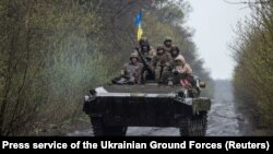 Ukrainian servicemen ride atop an armored fighting vehicle at an unknown location in eastern Ukraine. The image was released on April 19. 