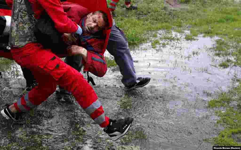 Medical workers carry an injured man following shelling in Kharkiv on April 27.&nbsp;