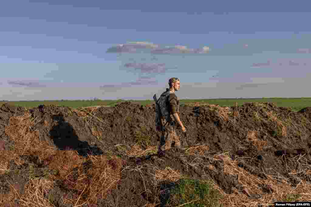 A Ukrainian serviceman walks in a trench alongside a checkpoint in the Zaporizhzhya region on April 27.&nbsp;