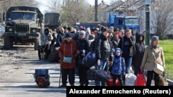 Evacuees wait to board a bus leaving the city of Mariupol in April. The data gleaned at filtration centers in Russia-controlled parts of Ukraine like Mariupol could be invaluable as the Kremlin moves forward with plans to hold so-called referendums in the occupied regions on joining Russia.