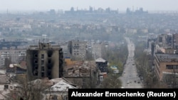 Damaged buildings are pictured in Mariupol on April 19, with the Azovstal steel works plant in the background.