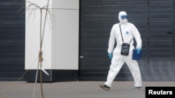 A medical specialist wearing protective gear walks outside a hospital for patients infected with the coronavirus on the outskirts of Moscow on March 23.