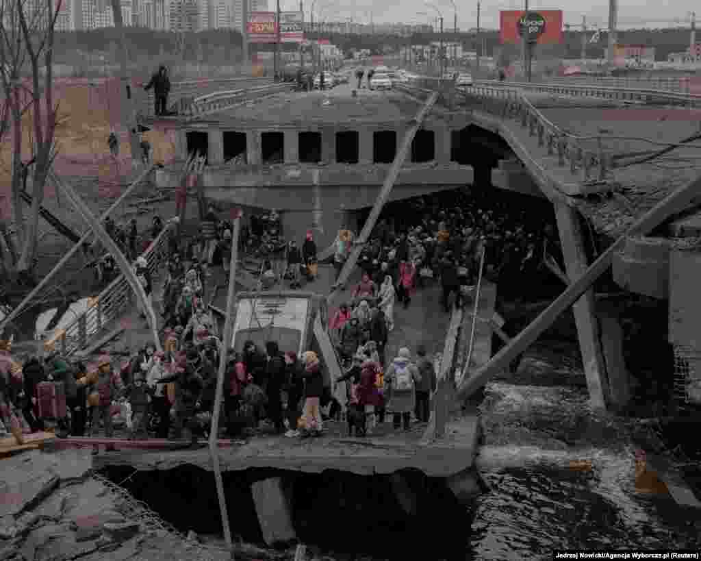 People cross a destroyed bridge as they try to leave the city of Irpin on March 5.