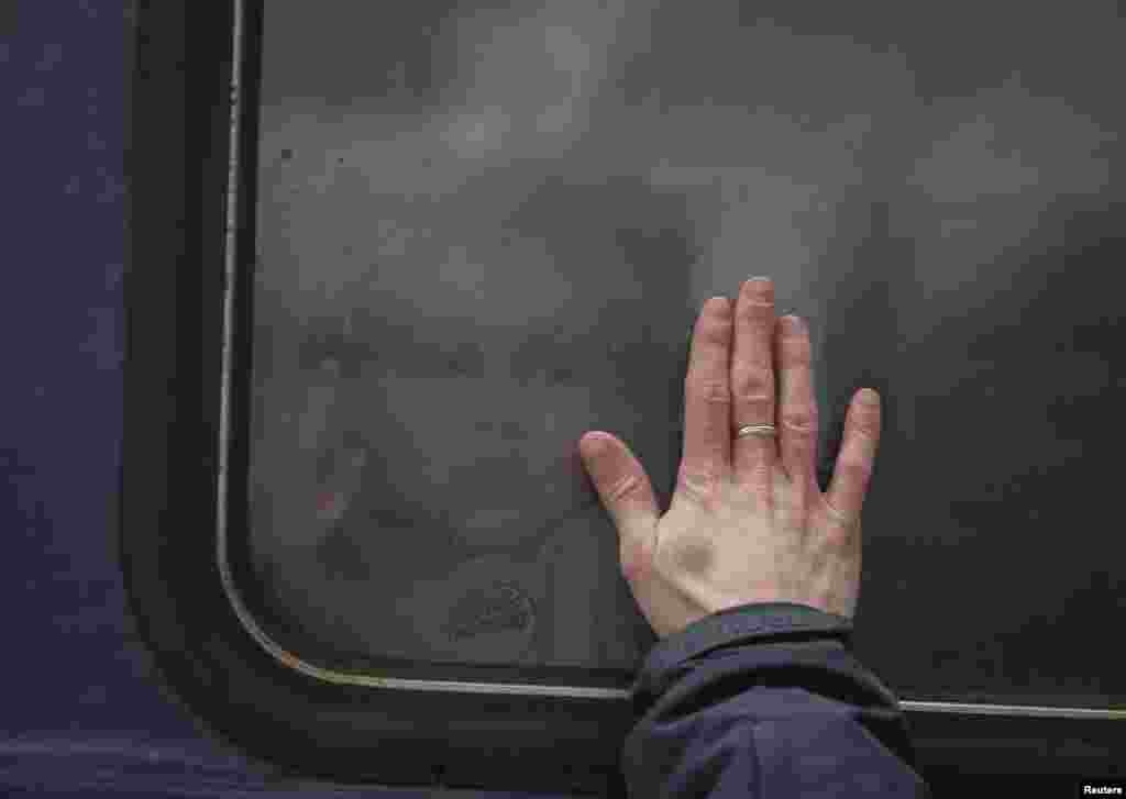 A child says goodbye to his father through the window of an evacuation train leaving from Kyiv to Lviv at Kyiv&#39;s central train station on March 6.