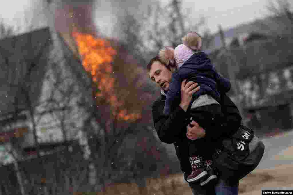 A man and a child try to escape from the town of Irpin on March 6 after heavy Russian shelling.