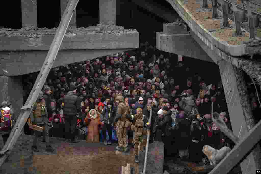 Ukrainian civilians crowd under a destroyed bridge as they try to flee Irpin on the outskirts of Kyiv on March 5.