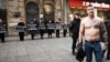 A man with a large tattoo on his chest of Bosnian Serb wartime commander Ratko Mladic, a convicted war criminal, stands near a protest against Russia's invasion of Ukraine on March 16.