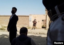 A Taliban soldier stands guard outside a house in Kabul near the IS-K hideout raided by Taliban forces on October 3.