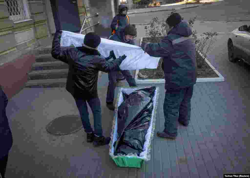 Funeral directors place an unidentified body in a coffin on December 5. Ukrainian President Volodymyr Zelenskiy ordered the evacuation of residents in the eastern Donetsk region on July 30. Yet many residents refused to leave.