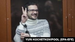 Ilya Yashin gestures inside a defendant's cage prior to his court hearing in Moscow on December 9. 