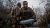 A Ukrainian artilleryman carries a 122-mm shell for a 2S1 Gvozdika self-propelled howitzer at a position along the front line near Bakhmut on December 10.