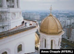 Workers on a ledge alongside the main cupola of the cathedral.