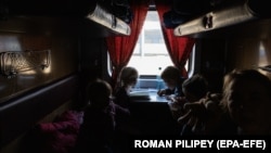 Orphaned children sit in an evacuation train at the railway station in Zaporizhzhya, southeastern Ukraine, on March 26, 2022.