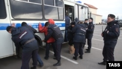 Police detain alleged illegal migrants during a raid at the Sadovod market in Moscow in 2013.