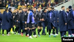 Kosovar players walk off the pitch in Bucharest.