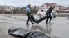 Communal workers carry body bags in the town of Bucha on April 3.