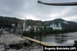 The Holy Mountains Lavra of the Holy Dormition, an Orthodox monastery, is seen from a destroyed bridge across the Siverskiy Donets River in the town of Svyatohirsk in October 2022.