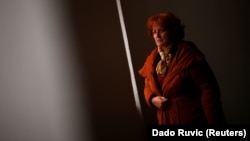 Nusreta Sivac, a Bosnian War rape victim, looks through a window in one of several camps where she was detained, in Trnopolje near Prijedor, Bosnia-Herzegovina. (file photo)