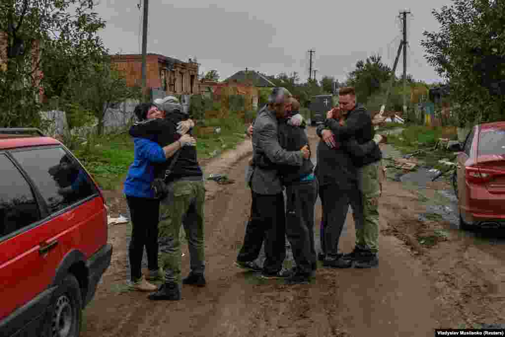 Neighbors embrace each others after they return to the liberated village of Kamyanka on October 2 in the Kharkiv region. &nbsp;