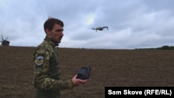 Instructor Ilya Trokhin demonstrates the controls of an unmanned aircraft at the Kruk drone school in Kyiv. 