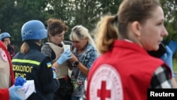 Counselors aid victims of a convoy of civilian vehicles that was hit by a Russian missile strike in Zaporizhzhya, Ukraine, on September 30.