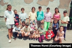 The photo showing Amel Hodzic, standing in the center, in a long-sleeved turquoise shirt, and Dzemil Hodzic, standing, far right, and other neighborhood kids squinting against a bright sun in Sarajevo under siege in 1993.