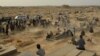 Mourners gather next to graves of victims of the October 8 suicide bomb attack on worshippers at a Shi'ite mosque in Kunduz, in which at least 55 people died. The attack was claimed by the Islamic State-Khorasan.