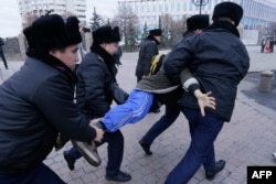 Kazakh police detain a protester during a rally on the day of the Kazakh presidential election in Almaty on November 20, 2022.