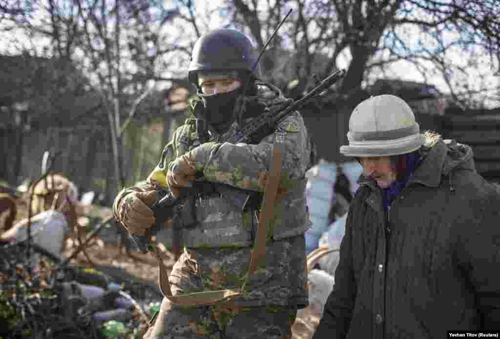 A Ukrainian soldier escorts a local resident on December 7. Not only the shelling, but the winter months without electricity and water pose serious challenges to Bakhmut&#39;s residents.