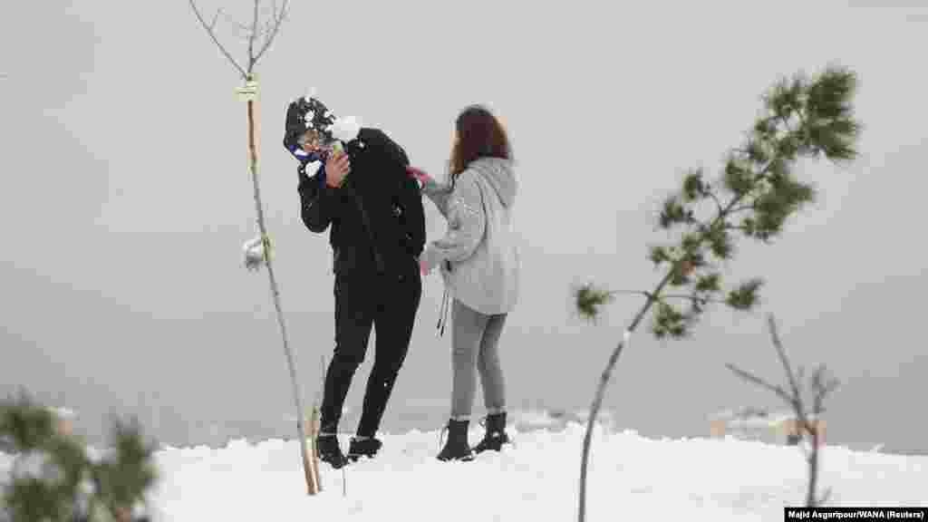 This December 24 photo, of a young couple playing with snow on a hilltop above Tehran, is one of several recent images showing Iranian women in public without the hijab, the Islamic head covering that has been mandatory for women in Iran since 1983.&nbsp;