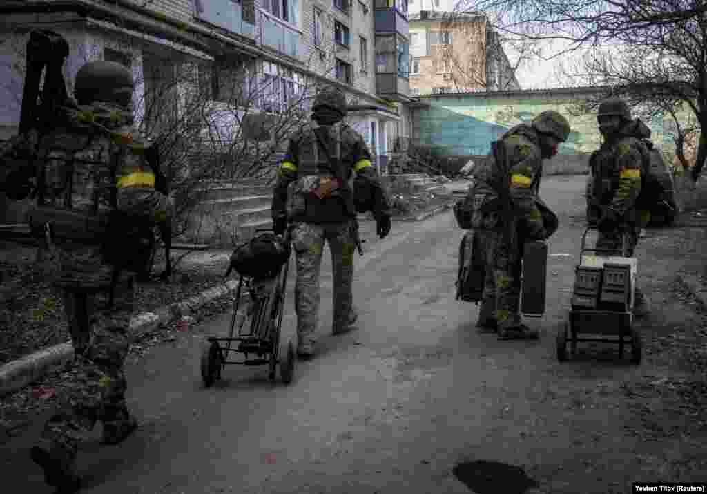 Ukrainian service members move weapons and ammunition through the empty streets of Bakhmut on December 7. Western allies have provided the Ukrainian military with cold-weather gear in addition to weapons and ammunition to help them survive the winter. &nbsp;